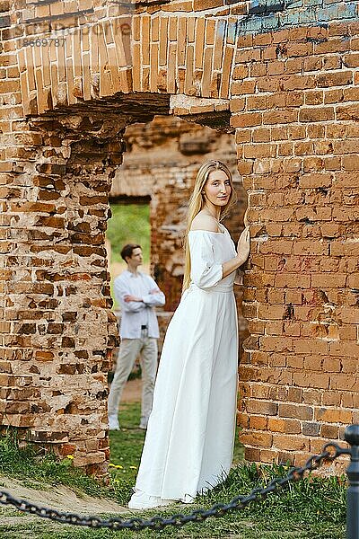 Junges verliebtes Paar posiert inmitten einer Burgruine
