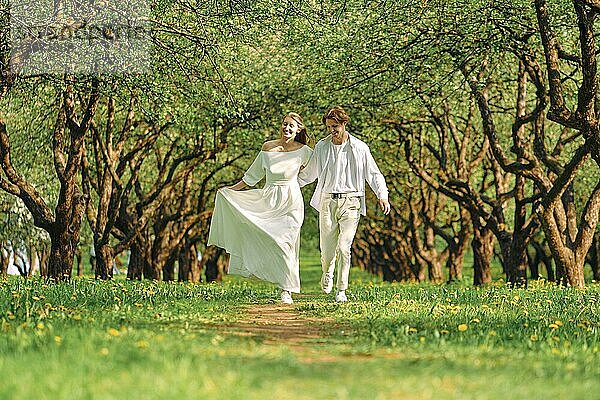 Verliebtes Paar umarmt sich und spaziert einen Weg im Park entlang
