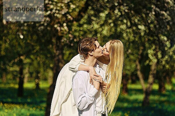Blonde Frau küsst ihren Freund im Freien