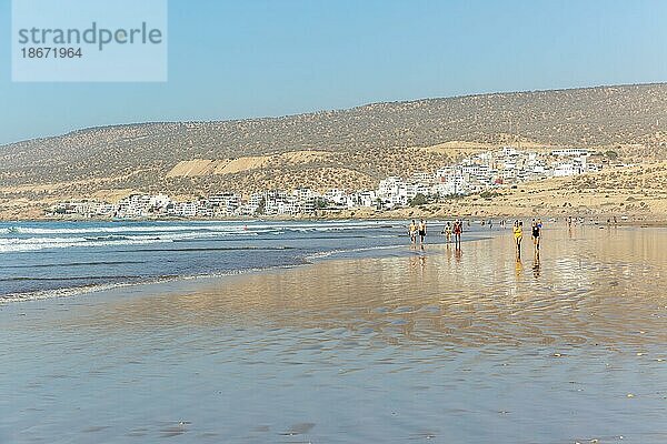 Spaziergänger am Sandstrand bei Ebbe in der Nähe des Dorfes Taghazout  Marokko  Nordafrika  Afrika
