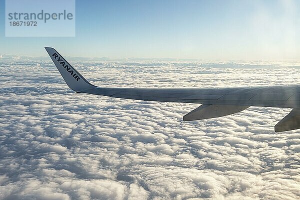 Flügel einer Boeing 737 der Fluggesellschaft Ryanair  die in großer Höhe über den Wolken fliegt