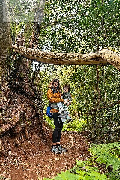 Porträt von Mutter und Sohn in einem Baum auf einem Wanderweg im moosbewachsenen Wald des Nationalparks Garajonay  La Gomera  Kanarische Inseln. Auf dem Ausflug nach Las Creces