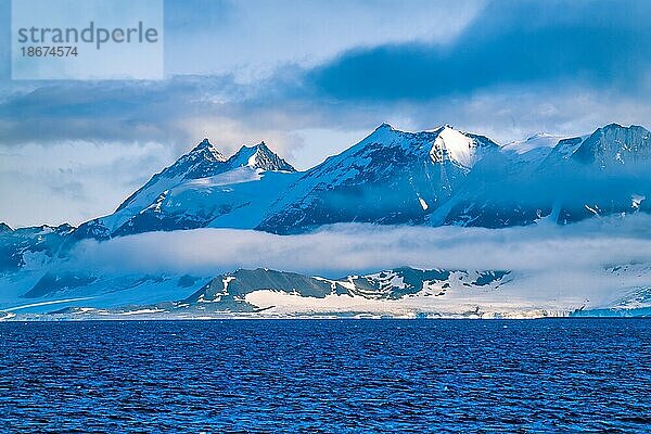 Felsenküste mit tief hängenden Wolken am Meer in der Arktis  Svalbard  Spitzbergen  Norwegen  Europa