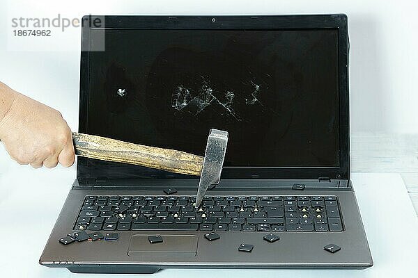 Arm eines Mannes  der einen Laptop mit einem Hammer zerschlägt  vor weißem Hintergrund und Kopierraum