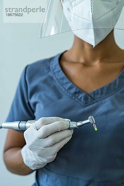 Zahnarzt mit Handschuhen bei der Arbeit mit einem Zahnbohrer in einer Zahnarztpraxis. Nahaufnahme  selektiver Fokus