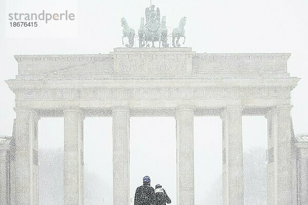 Berlin  Ein Pärchen  aufgenommen auf dem Pariser Platz vor dem Brandenburger Tor nach während starken Schneefalls in Berlin