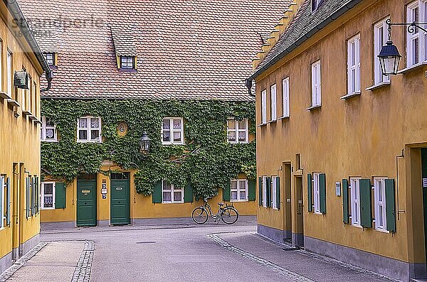 Fuggerei  Augsburg  Bayern  Deutschland  Blick durch eine der Gassen mit den Armenhäusern  Europa