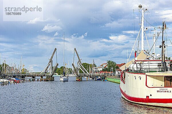 Ein Segelboot ist dabei  im Stadthafen Greifswald-Wieck die alte historische Holzklappbrücke zu passieren  Hansestadt Greifswald  Mecklenburg-Vorpommern  Deutschland  Europa