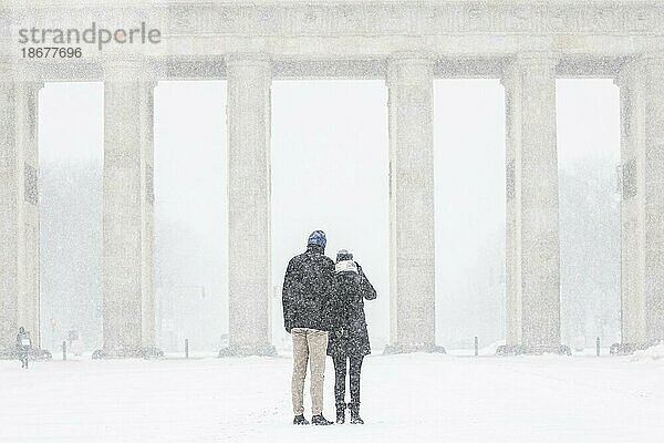 Berlin  Ein Pärchen  aufgenommen auf dem Pariser Platz vor dem Brandenburger Tor nach während starken Schneefalls in Berlin