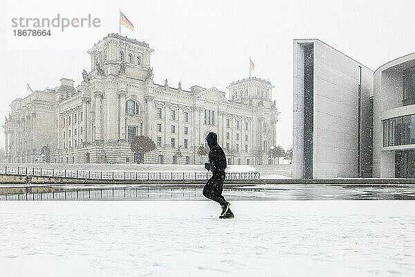 Berlin  Eine Person zeichnet sich am Spreebogen zwischen Reichstagsgebäude und Paul  Löbe  Haus ab  aufgenommen während starken Schneefalls in Berlin