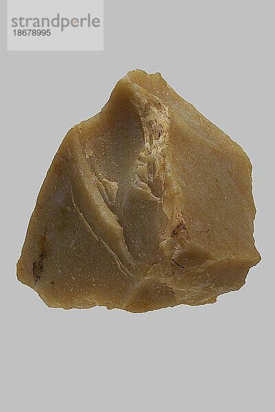 Nahaufnahme eines braunen  strukturierten indischen Karmelsteins auf grauem Hintergrund