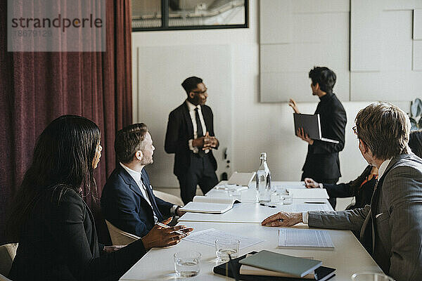 Männliche und weibliche Unternehmer bei einer Geschäftsbesprechung im Sitzungssaal eines Büros