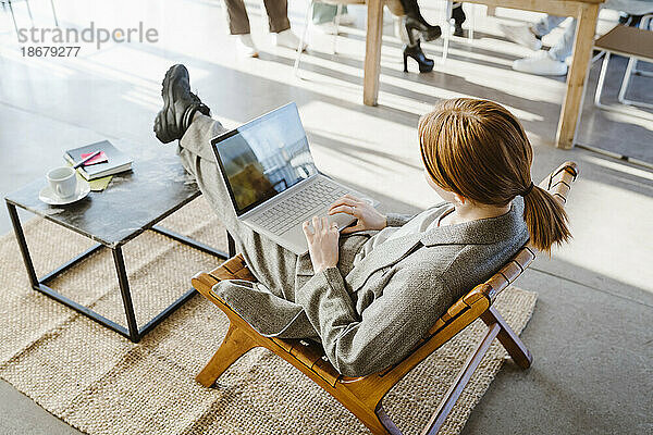 Hohe Winkel Ansicht der Geschäftsfrau mit Laptop beim Sitzen im Stuhl im Büro