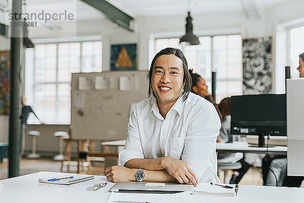 Porträt eines lächelnden Geschäftsmannes an einem modernen Arbeitsplatz