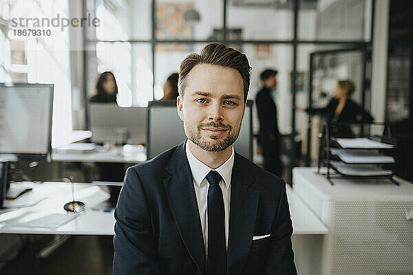 Porträt eines männlichen Unternehmers mit schwarzem Blazer im Büro