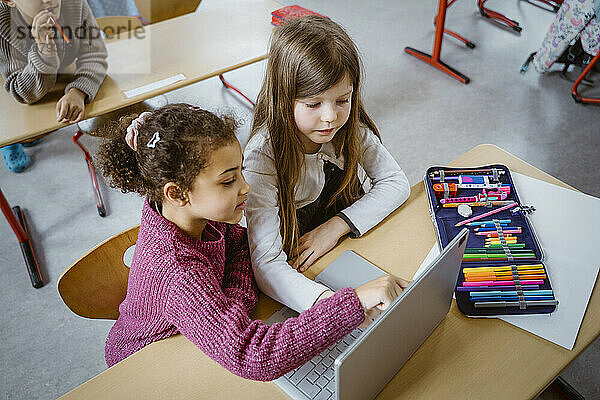 Hohe Winkel Ansicht der Schülerinnen mit Laptop zusammen am Schreibtisch im Klassenzimmer