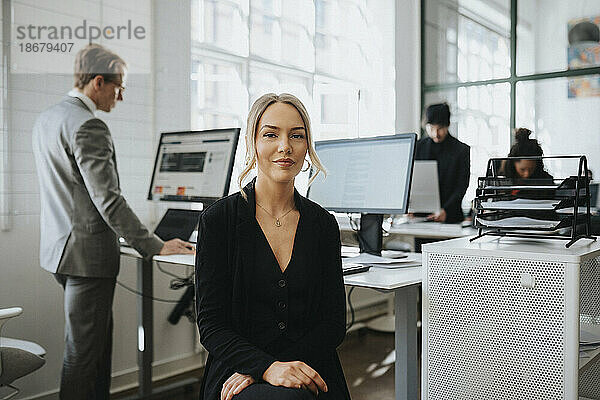 Porträt einer jungen Geschäftsfrau  die im Büro sitzt