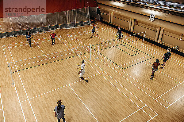 Hohe Winkel Ansicht der männlichen und weiblichen Athleten spielen Badminton auf Sportplatz