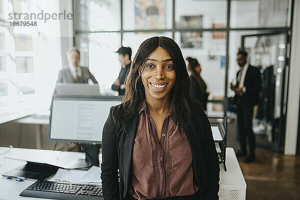 Porträt einer lächelnden Geschäftsfrau mit Blazer im Büro