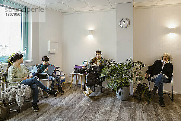 Patienten  die auf einem Stuhl sitzen und in der Klinik warten