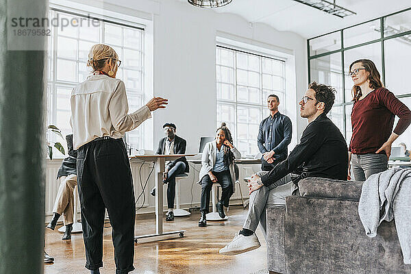 Weibliche Führungskraft bei einer Besprechung mit Kollegen in einem modernen Büro
