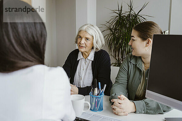 Ältere Frau mit Tochter im Gespräch mit dem Arzt bei einem Besuch in der Klinik