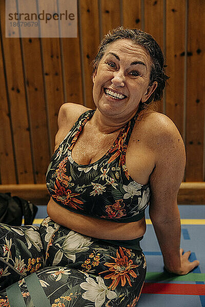 Porträt einer glücklichen Sportlerin beim Ausruhen auf einem Sportplatz