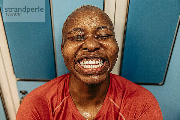 Hohe Winkel Ansicht der glücklichen weiblichen Athleten lachend mit geschlossenen Augen in der Umkleidekabine