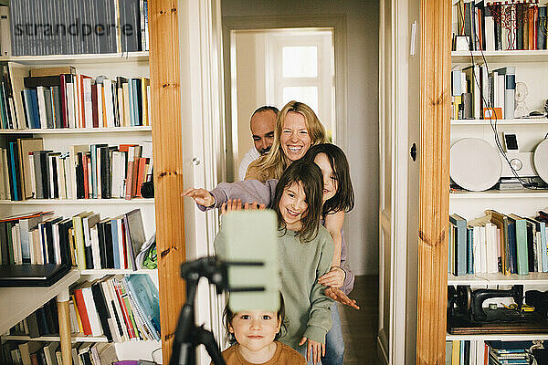 Glückliche Familie  die zu Hause mit dem Smartphone filmt