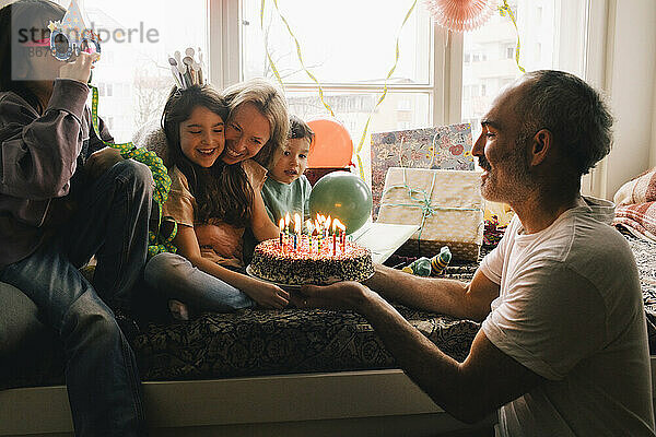 Glückliche Familie feiert Geburtstag mit Kuchen zu Hause