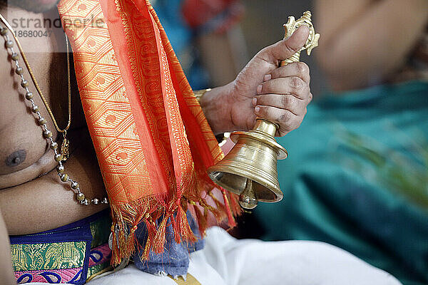 Hand hält zeremonielle Glocke  Sri Srinivasa Perumal Hindu-Tempel  Hindu-Priester (Brahmane) führt Puja-Zeremonie und Rituale durch  Singapur  Südostasien  Asien