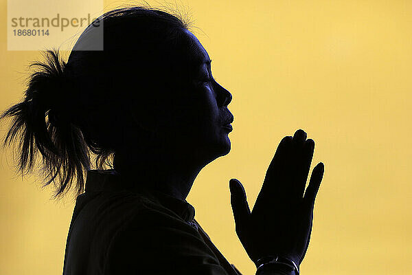 Silhouette of woman praying in temple  Faith and spirituality concept  Vietnam  Indochina  Southeast Asia  Asia