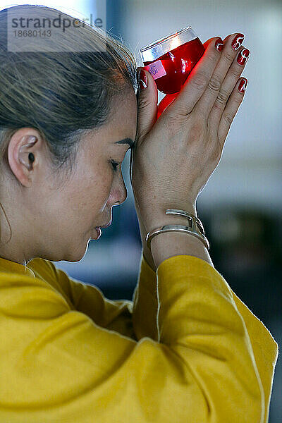 Buddhistischer Tempel Huynh Dao  Frau bei buddhistischer Zeremonie  die mit einer Kerze betet  Chau Doc  Vietnam  Indochina  Südostasien  Asien