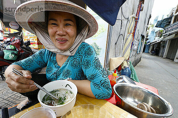 Frau isst traditionelle vietnamesische Suppe (Hu Tieu)  Ho-Chi-Minh-Stadt  Vietnam  Indochina  Südostasien  Asien