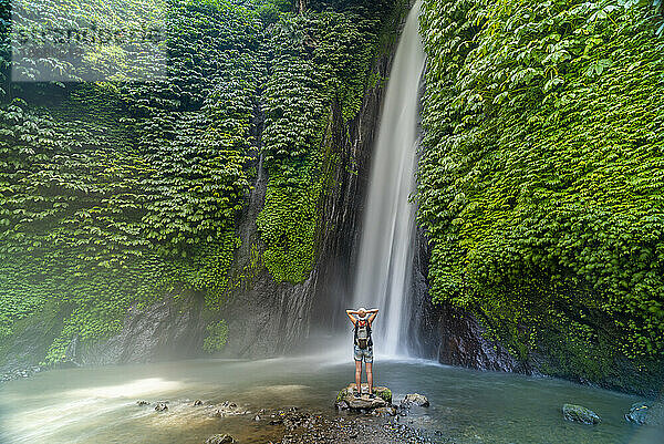 Blick auf eine Frau  die am Melanting-Wasserfall  Kabupaten Buleleng  Gobleg  Bali  Indonesien  Südostasien  Asien fotografiert