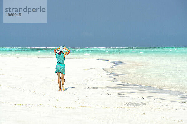 Frau geht am idyllischen  leeren Strand  Sansibar  Tansania  Ostafrika  Afrika