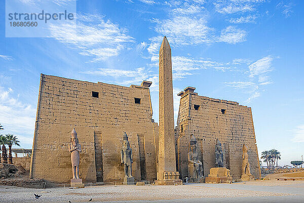 Der Pylon von Ramses II. mit dem östlichen Obelisken und den beiden Kolosse des auf seinem Thron sitzenden Königs  Luxor-Tempel  Luxor  Theben  UNESCO-Weltkulturerbe  Ägypten  Nordafrika  Afrika