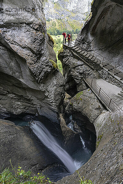 Zwei Wanderer fotografieren die Trummelbachfälle vom Pfad in majestätischen Felsschluchten aus  Lauterbrunnen  Kanton Bern  Schweiz  Europa