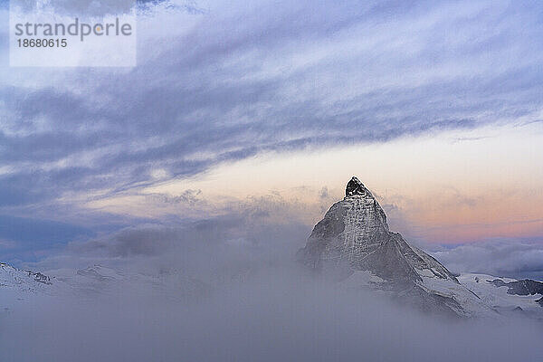 Wolken über dem Gipfel des Matterhorns  die bei Sonnenaufgang aus dem Nebel auftauchen  Gornergrat  Zermatt  Kanton Wallis  Schweiz  Europa