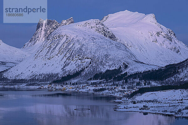 Morgenlicht über dem Dorf Bergsbotn und Bergsfjord im Hintergrund des Berges Luttinden im Winter  Bergsbotn-Gebirge  Senja  Kreis Troms og Finnmark  Norwegen  Skandinavien  Europa