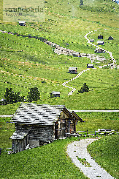 Typische alpine Holzhütten auf grünen Wiesen  Dolomiten  Puez-Geisler  Bezirk Bozen  Südtirol  Italien  Europa