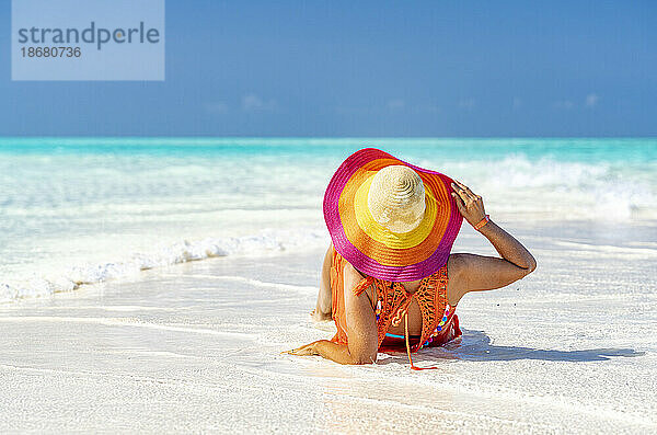Frau mit Hut entspannt sich am idyllischen  leeren Strand  Sansibar  Tansania  Ostafrika  Afrika