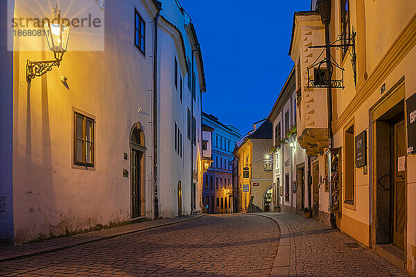 Beleuchtete Straßenlaterne in leerer Straße im historischen Zentrum in der Dämmerung  UNESCO-Weltkulturerbe  Cesky Krumlov  Südböhmische Region  Tschechische Republik (Tschechien)  Europa