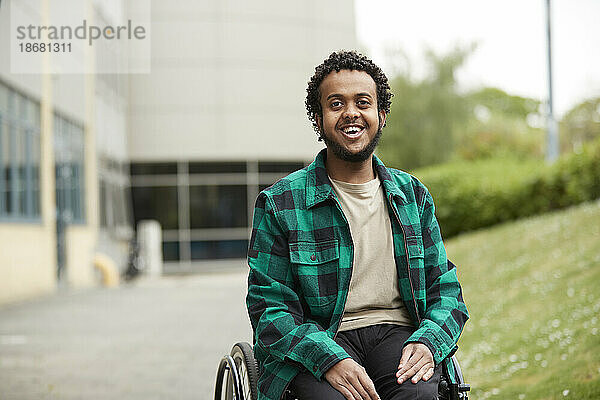 Porträt eines lächelnden jungen Mannes im Rollstuhl