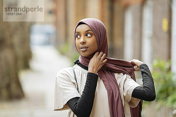 Junge Frau passt Hijab im Freien an