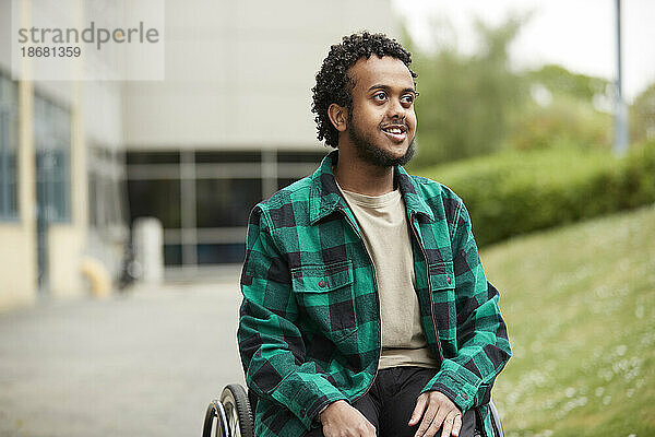 Lächelnder junger Mann im Rollstuhl