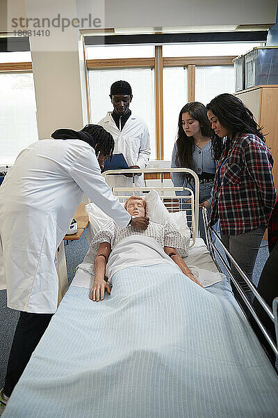 Medizinstudenten (16-17) führen eine medizinische Untersuchung an einer Puppe durch