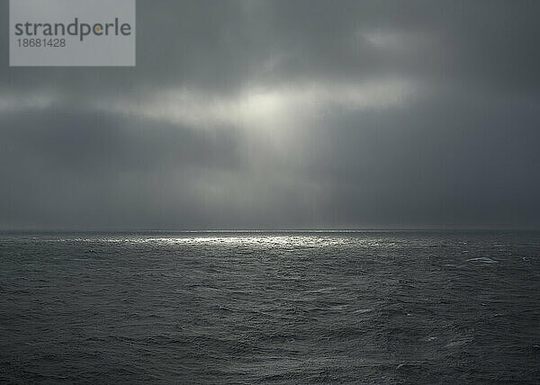 Sonne scheint durch Gewitterwolken über der Nordsee  Niederlande