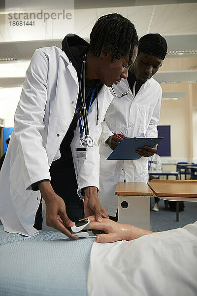 Medizinstudenten verwenden Pulsoximeter an einer Puppe