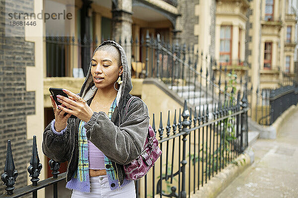 Junge Hipster-Frau benutzt Telefon auf der Straße